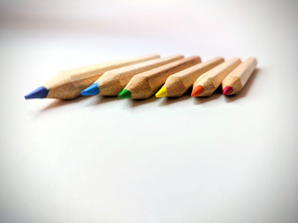 白い机に並ぶ6本の色鉛筆